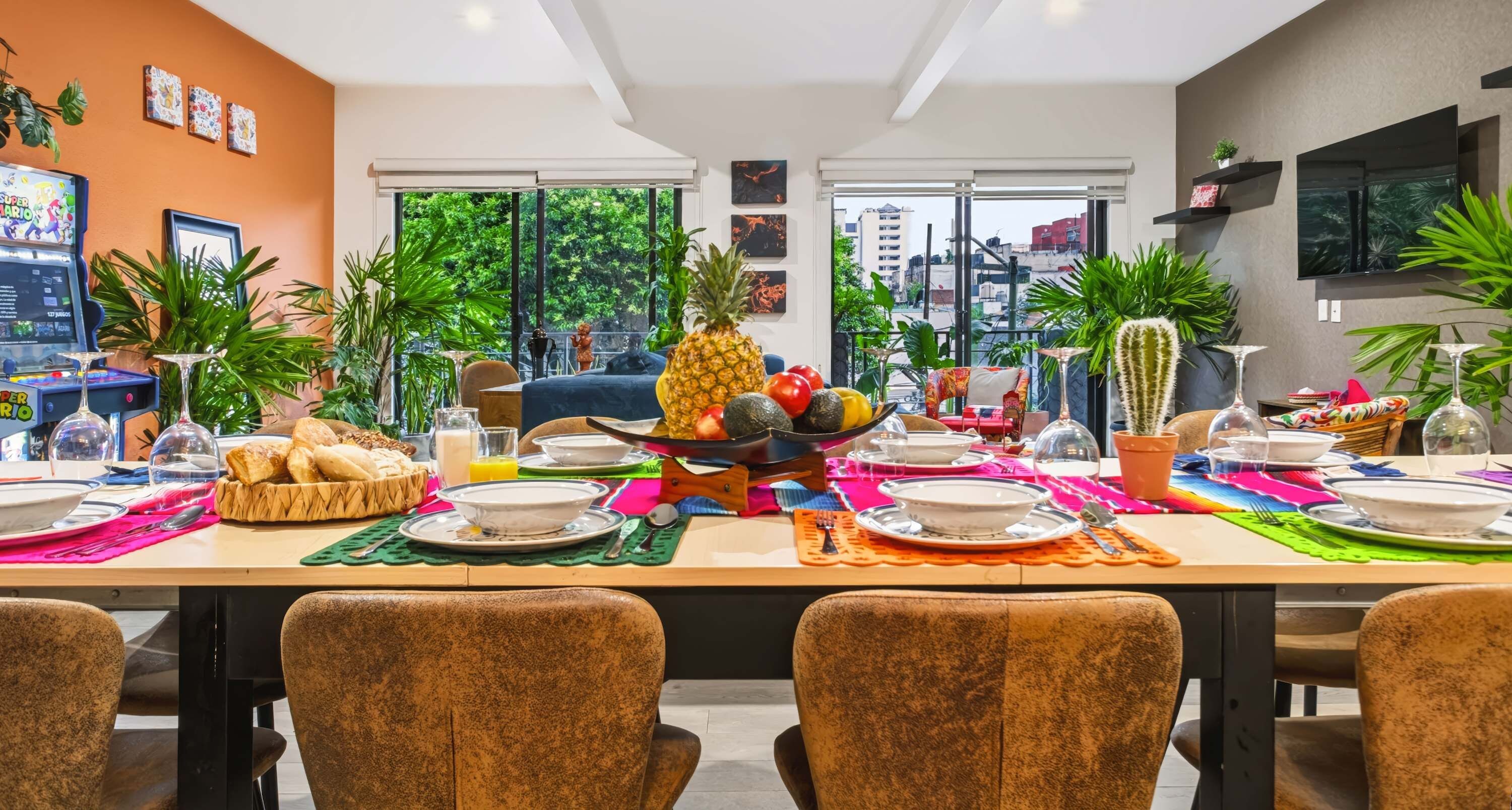 Un coin repas avec une table mise pour le repas, entourée de chaises, et offrant une vue sur la verdure à l’extérieur.