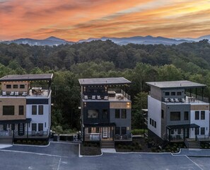 A modern multi-story residential building with a flat roof, large windows, and a balcony. - Luxury Cabin with Rooftop Views & Indoor Pool near Dollywood in Pigeon Forge, TN (Pigeon Forge)