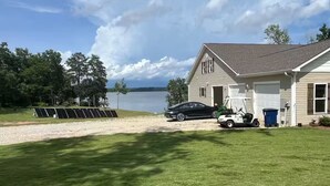 Talo, jossa on autotalli, auto, golfkärry ja aurinkopaneelit.