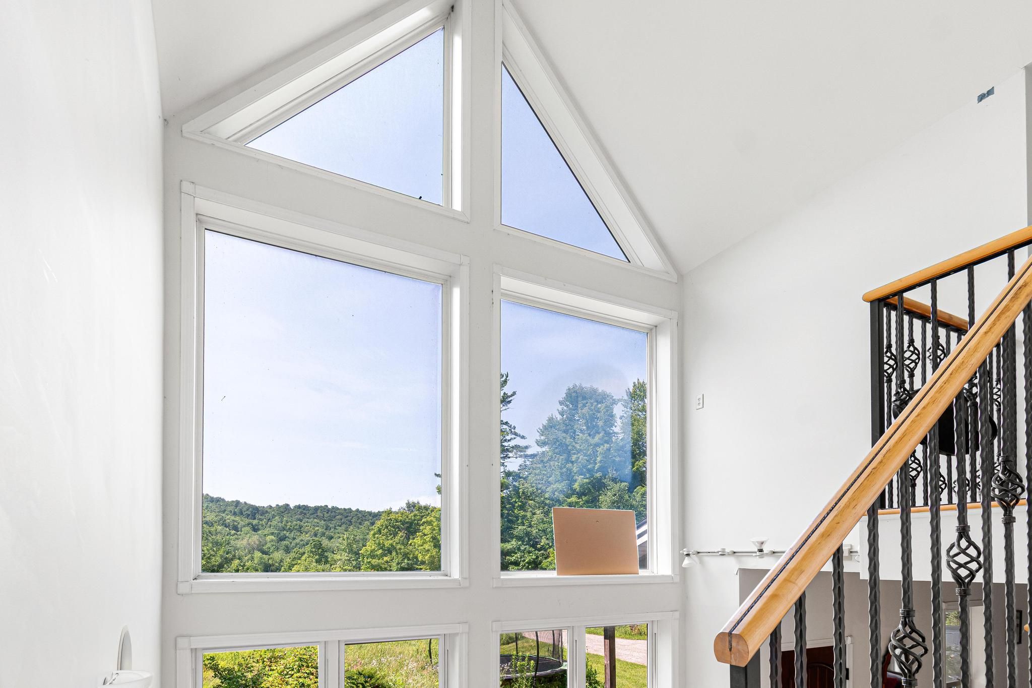 A room with a large skylight and a view of a green landscape.