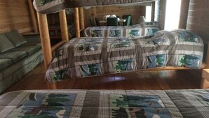 Een gezellige kamer met een bed, een bank en een houten vloer.