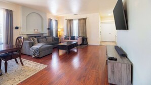 Uma sala de estar com sofá, mesa de centro, TV e lareira.
