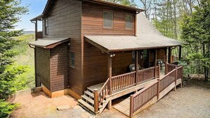 A two-story log cabin with a porch and a small staircase leading to the entrance. - Pristine 3-bedroom cabin with gorgeous views in Mineral Bluff (Mineral Bluff)