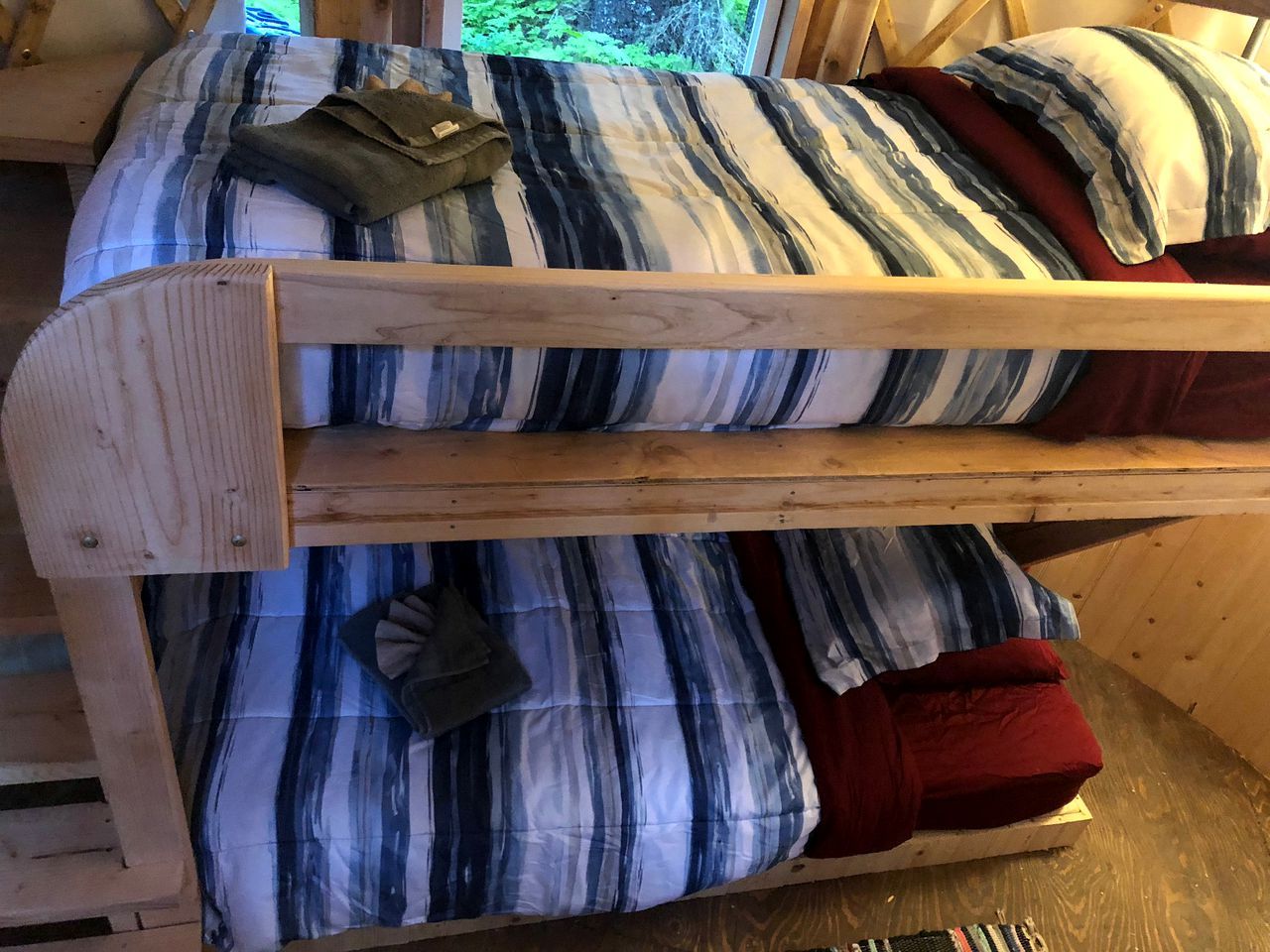 A bunk bed with striped bedding and pillows.