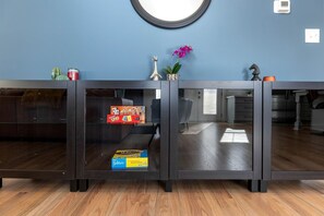 Un comptoir d’accueil avec un miroir, une plante en pot et une boîte de jeux.