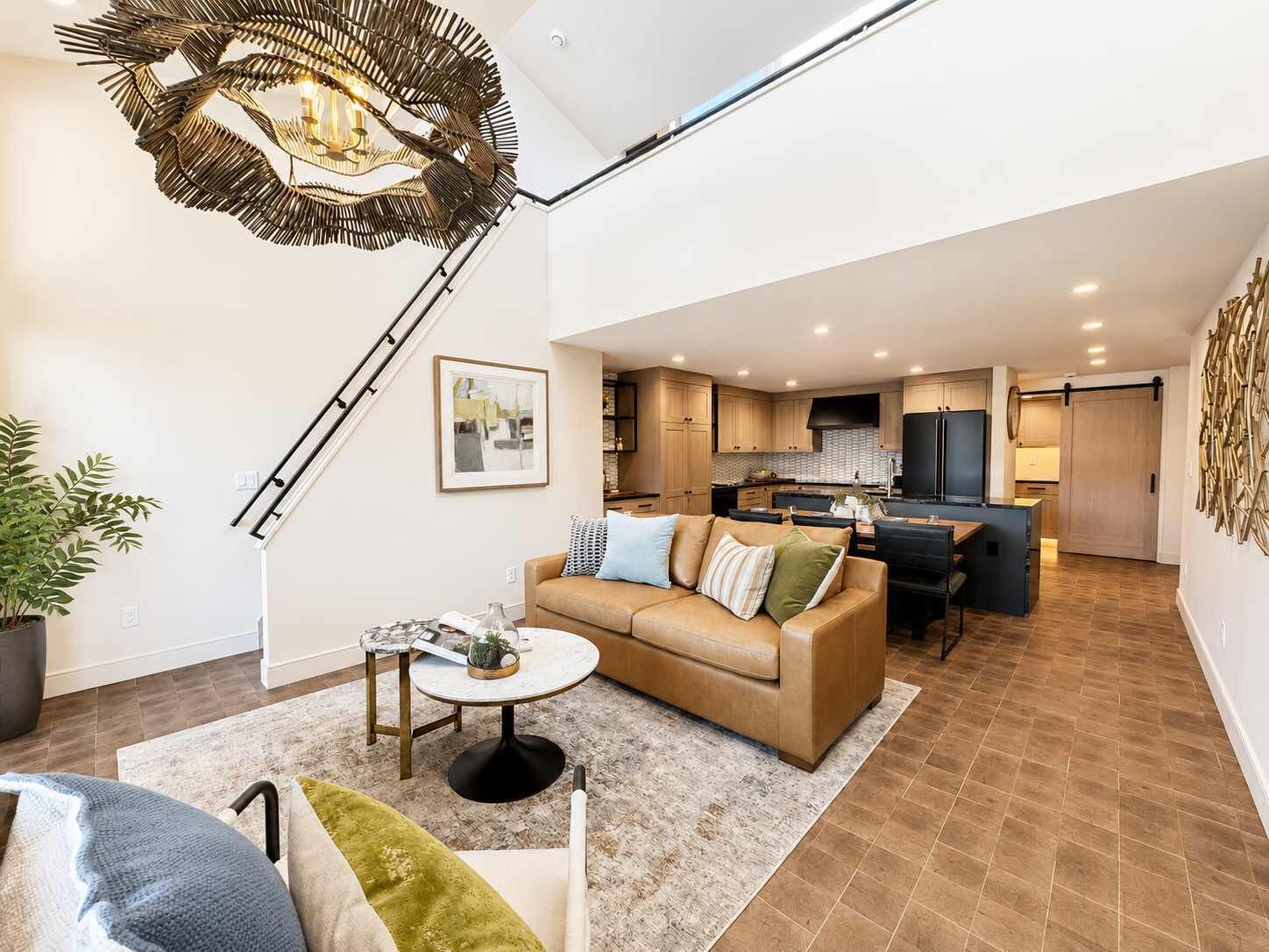 Un salon moderne avec un canapé, une table basse et un luminaire au plafond au design original.