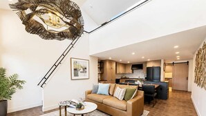 A modern living room with a sofa, coffee table, and a unique ceiling light fixture. - Designer Lakefront Condo E3, Wapato Point Chelan (Manson)