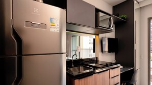 A modern kitchen with a stainless steel refrigerator, a microwave, and a sink. - Vnc consolation apt 614 (São Paulo)