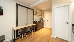 Una cocina compacta con lavamanos, encimera y un pequeño comedor con mesa y sillas.