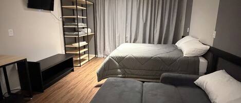 Una habitación de hotel moderna con una cama, un escritorio y un televisor.