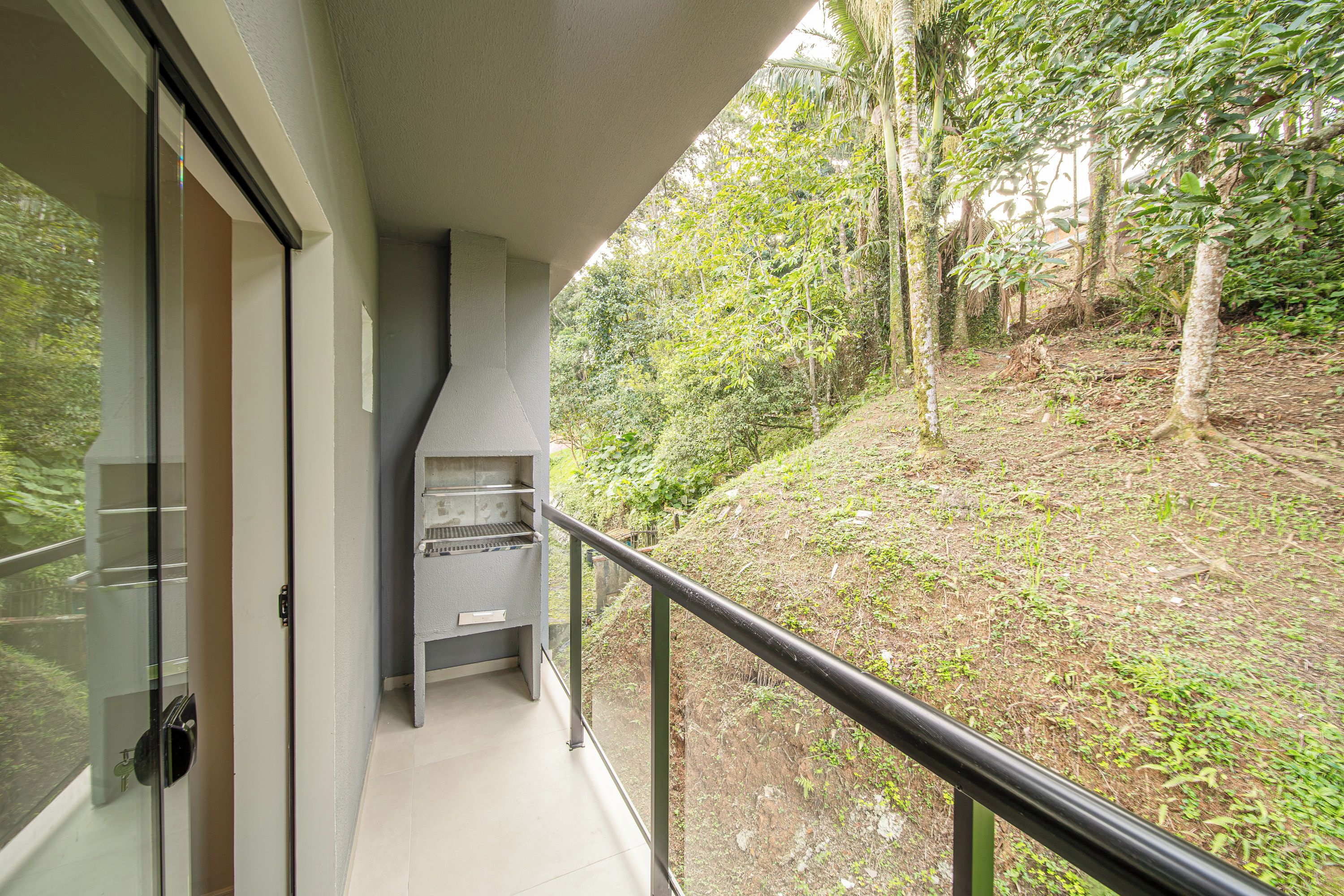 A balcony with a view of a forested area.
