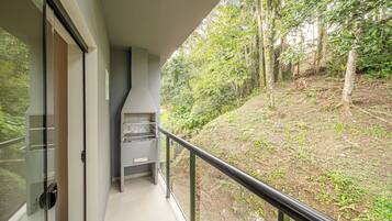 A balcony with a view of a forested area.