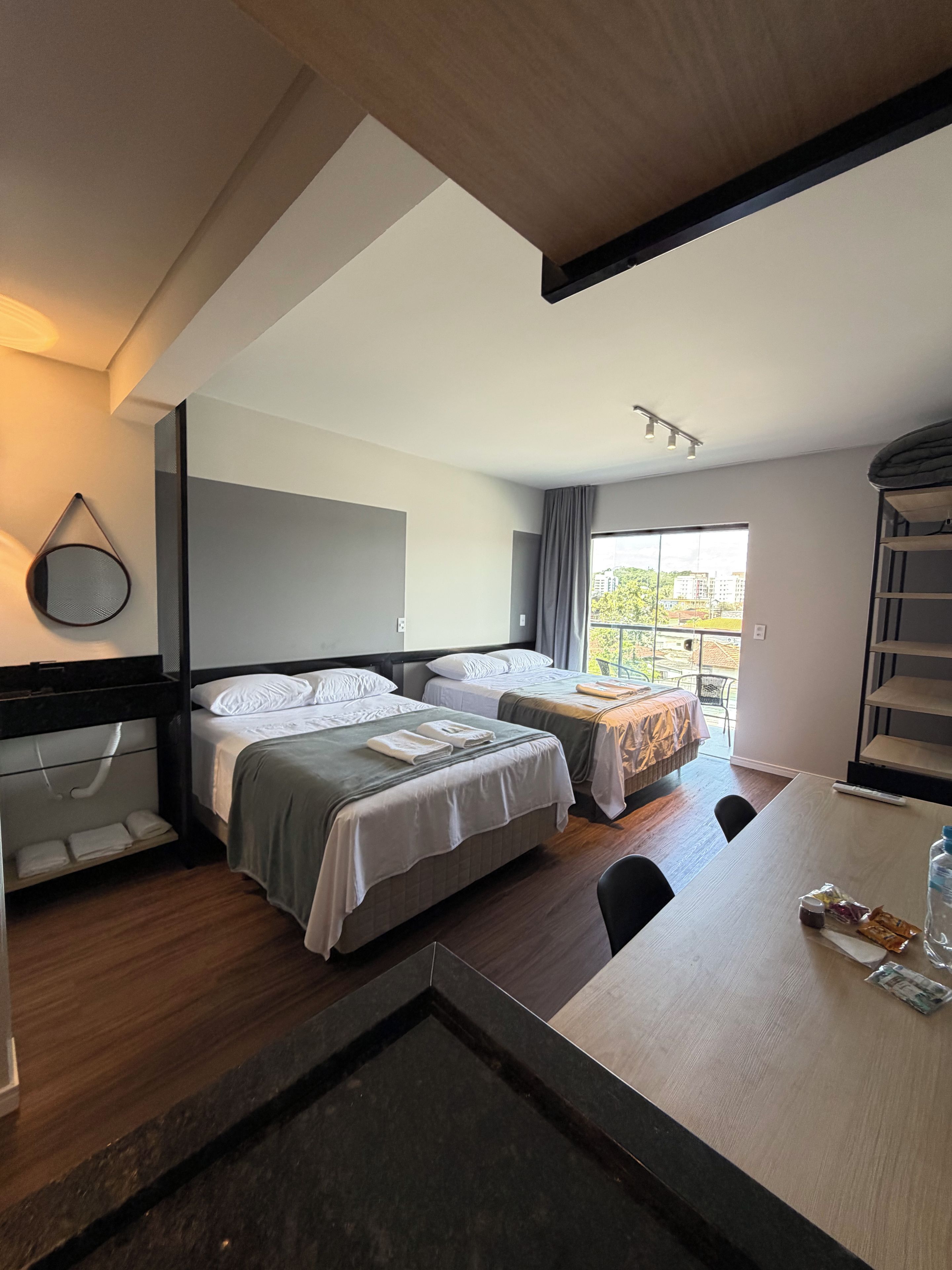 Une chambre d’hôtel avec deux lits, une table à manger et une vue sur l’extérieur.
