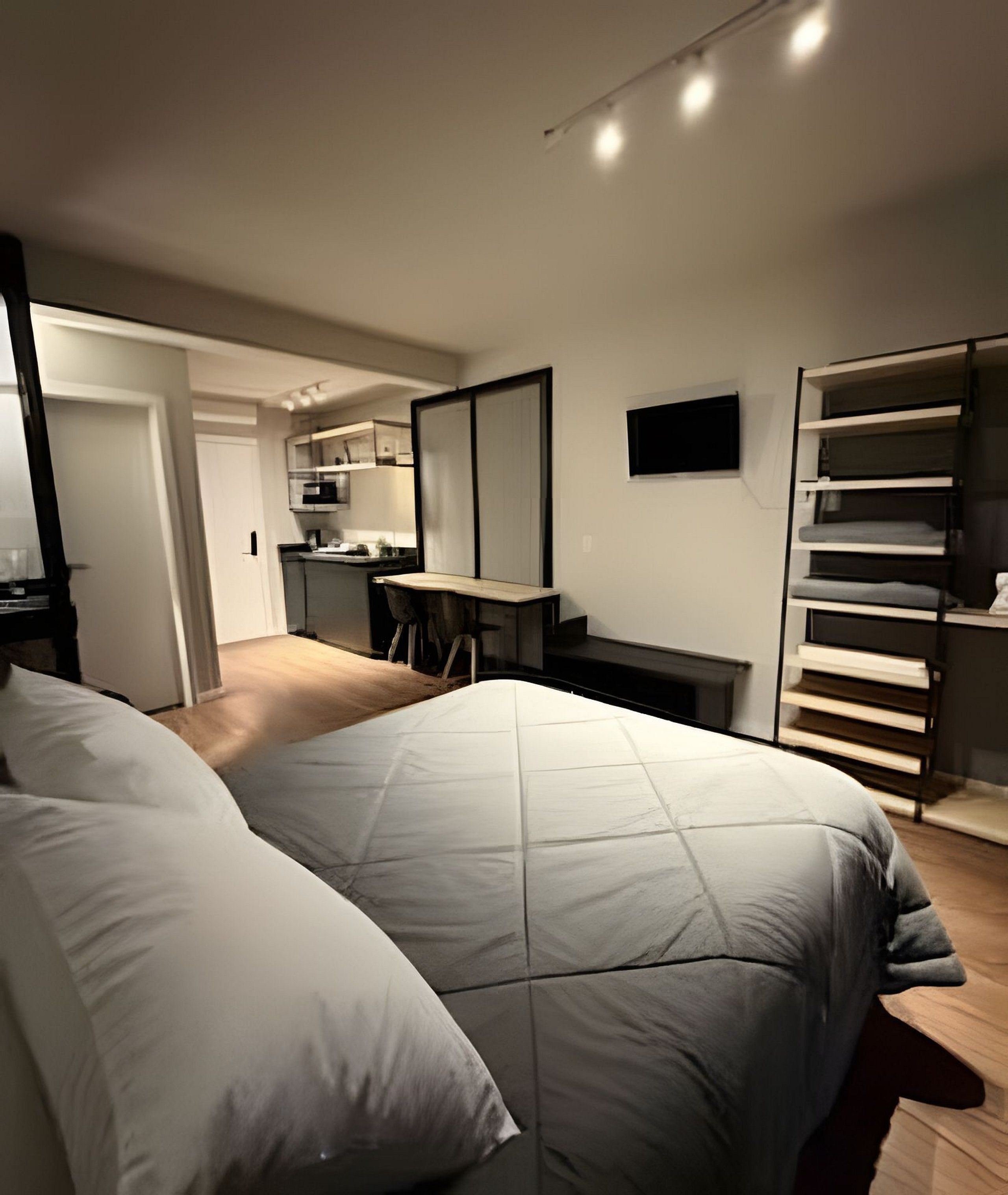 Un dormitorio moderno con una cama grande, un escritorio y un armario.