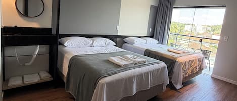 Una habitación de hotel moderna con dos camas, un ventanal grande y un balcón.
