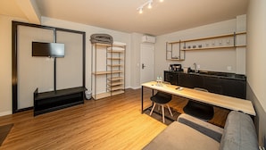 Un espacio habitable compacto con kitchenette, comedor y zona de estar.
