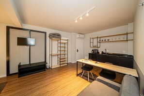 A compact living space with a kitchenette, a dining area, and a seating area. - Apez Smart Studio (Joinville)