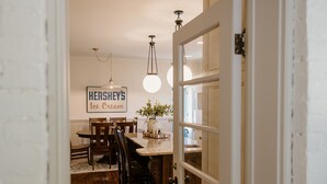 A dining area with a table, chairs, a sign reading 'Hershey's Ice Cream', and a door leading to another room.