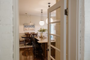 A dining area with a table, chairs, a sign reading 'Hershey's Ice Cream', and a door leading to another room.