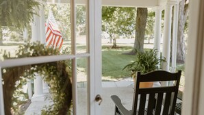 A porch with a bench, a wreath, and an American flag.