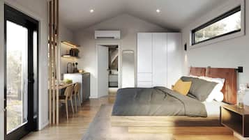 A modern bedroom with a large bed, a desk, and a view of the outdoors.