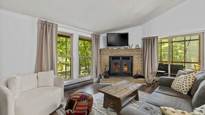 A living room with a fireplace, sofa, and a television.