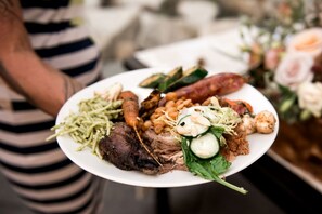 A plate of food with various items including meat, vegetables, and beans.