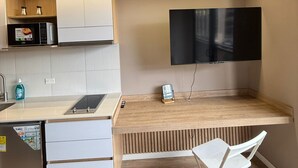 Uma cozinha moderna com micro-ondas embutido, pia e bancada de madeira.