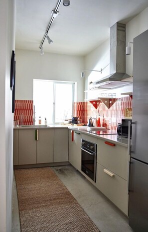 Eine Küche mit Fenster, Mikrowelle, Kühlschrank und Herd.