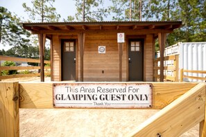 Eine Holzkonstruktion mit einem Schild, auf dem steht: 'Dieser Bereich ist nur für GLAMPING-GÄSTE reserviert.'