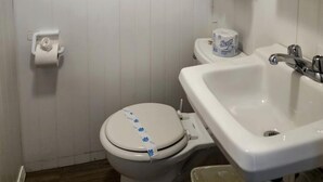 Ein Badezimmer mit Toilette, Waschbecken, Handtuchhalter und einem Fenster.