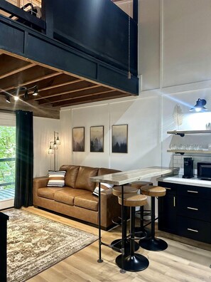 Une cuisine moderne avec un coin bar, un canapé et une table à manger.
