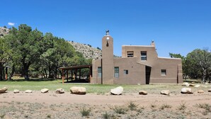 Un edificio con techo plano, chimenea y una pequeña torre.