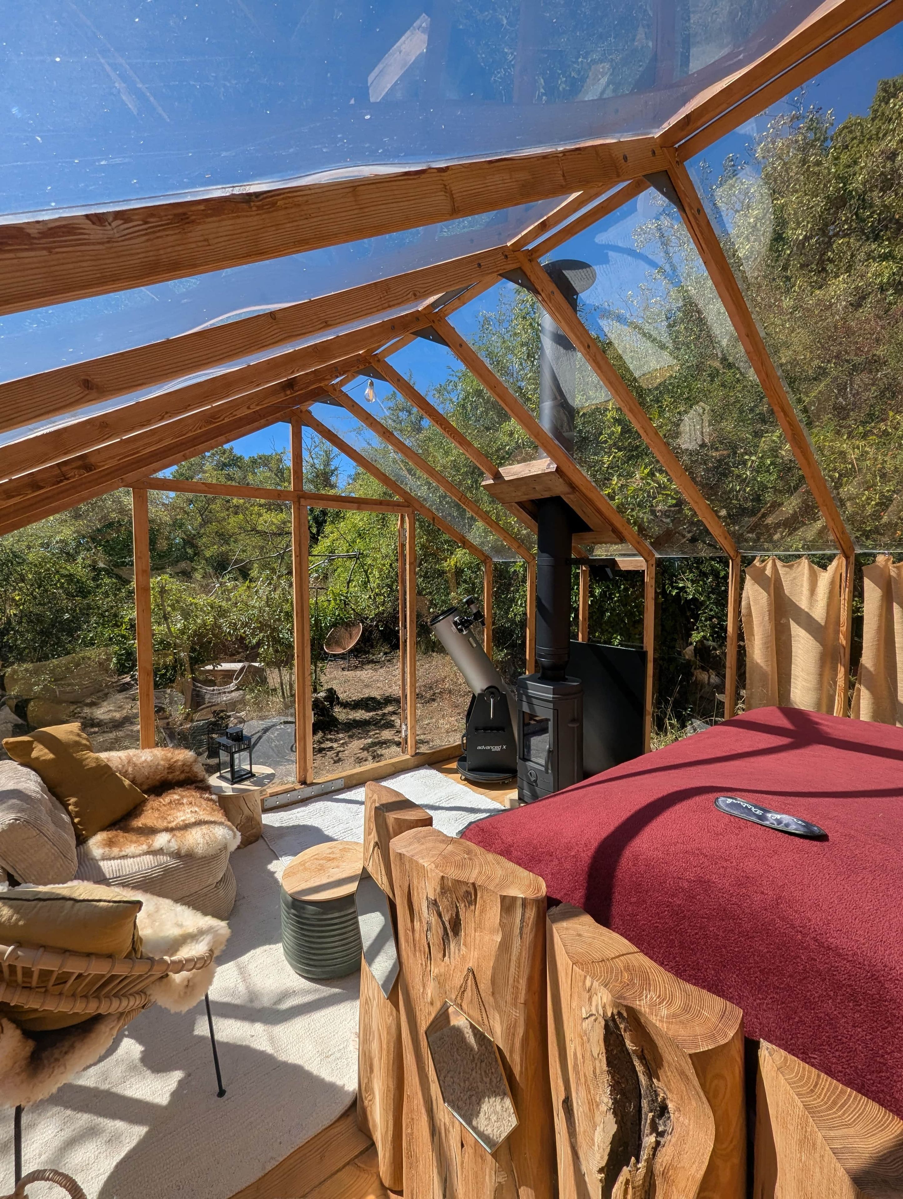 A wooden structure with a telescope, a red carpeted area, and a rustic wooden table.