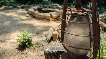 A rustic lantern on a wooden post in a forested area.
