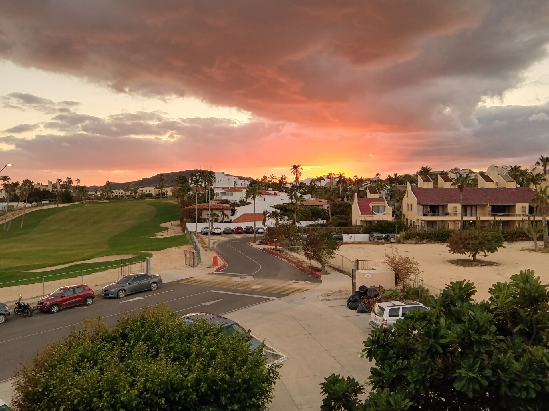 A residential area with houses, a road, and a golf course.