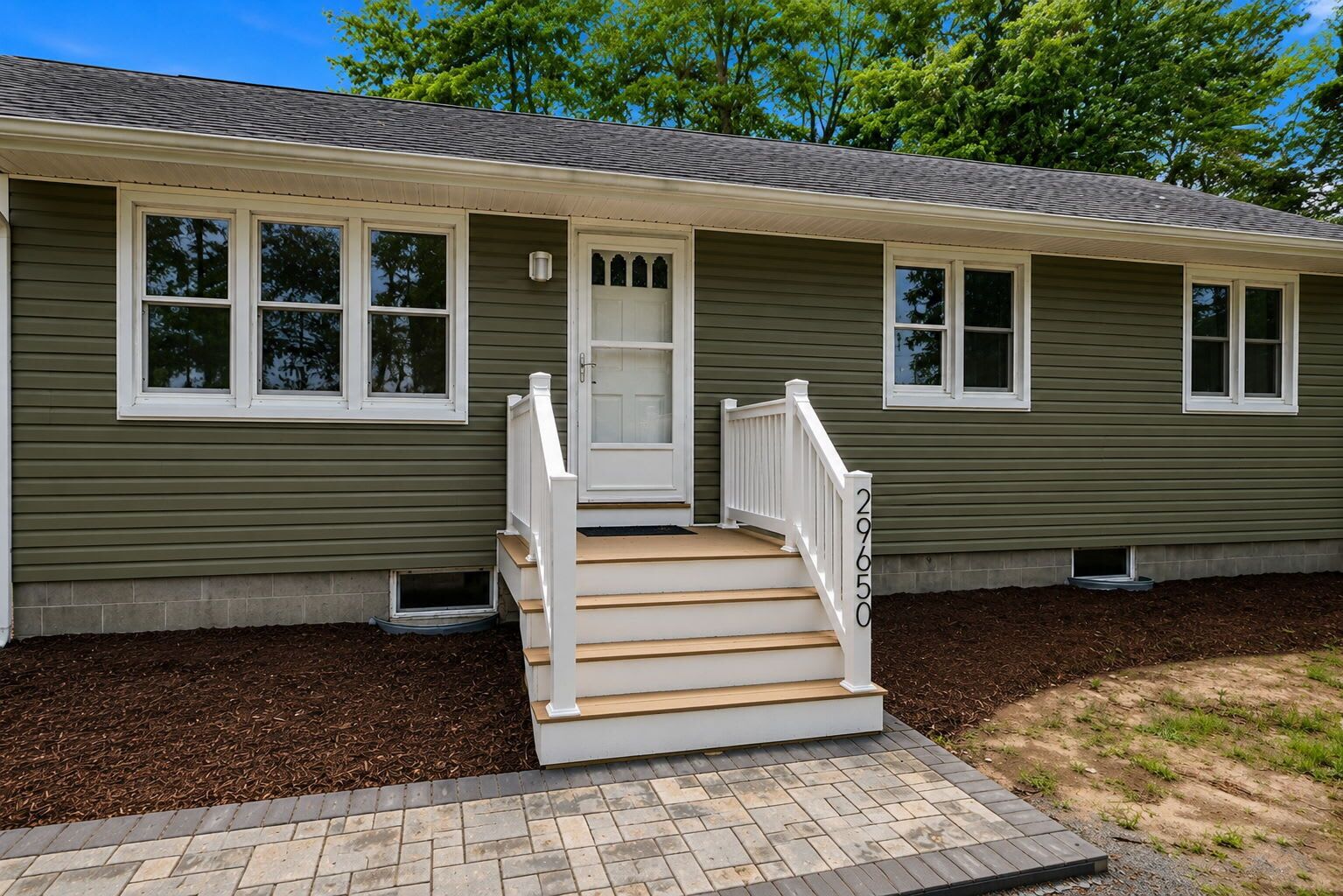 A two-story house with a front porch, a door, and a number '29650' on the side.