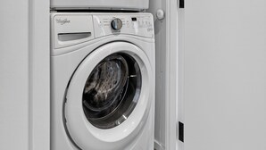 A front-loading Whirlpool washer and dryer unit with a wooden floor. - 2-bedroom Boutique Suite in SoWa Boston (Boston)