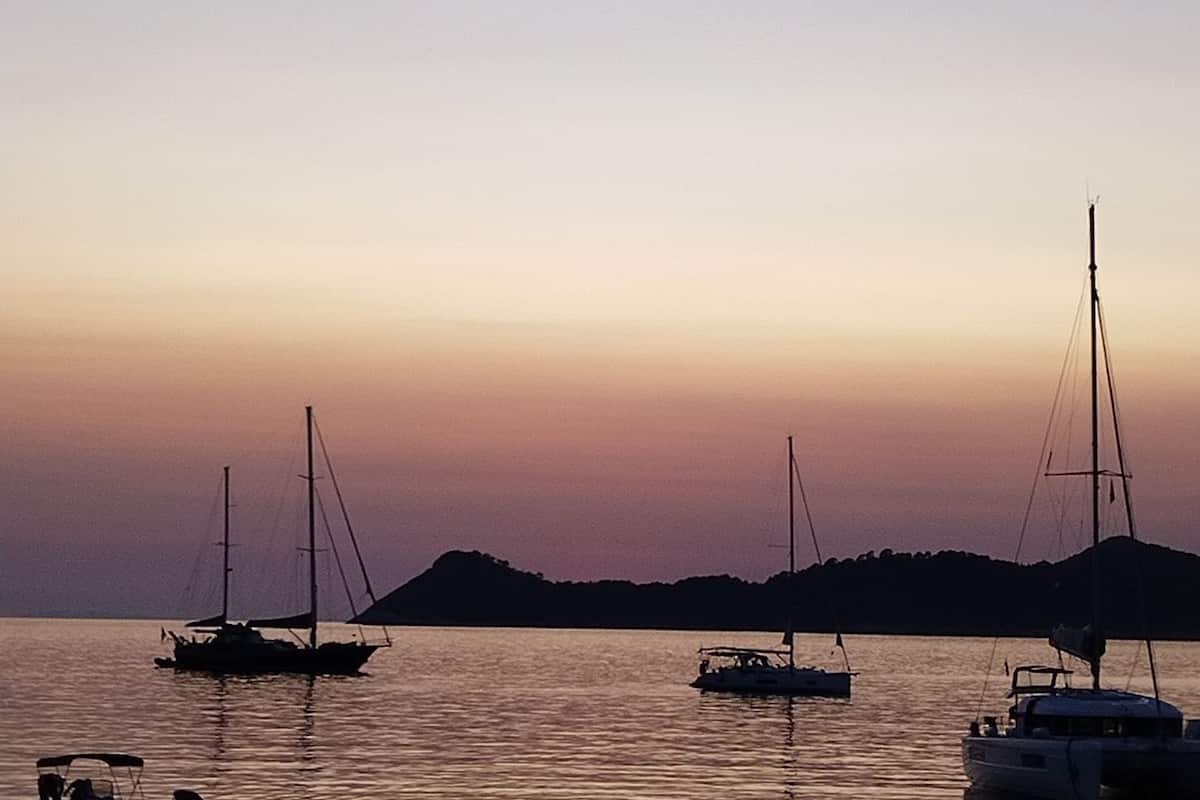 A marina with sailboats at sunset.