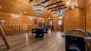 A wooden interior with a pool table, a ping pong table, and a billiards table. - Epic Group Cabin | Game Room + King Suites + Views (Sevierville)