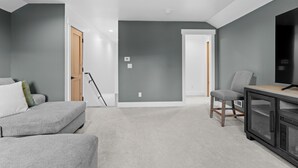 A modern living room with a grey sofa, a small table, and a TV.