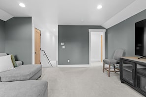 A modern living room with a grey sofa, a small table, and a TV.
