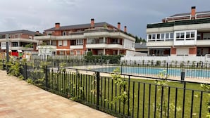 Et boligområde med swimmingpool, hegnet have og høje huse.