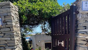 Un camí de pedra que condueix a una entrada tancada per una porta, amb un senyal que indica el número 18.