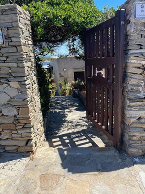 Un vialetto in pietra conduce a un cancello con un cartello che indica il numero 18.