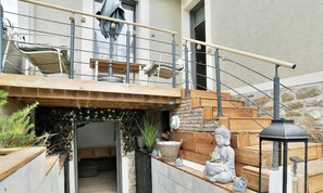 A residential property with a wooden staircase, outdoor seating area, and a small garden. - La Villa Caro - Terrasse - Sauna (Saint-Malo)