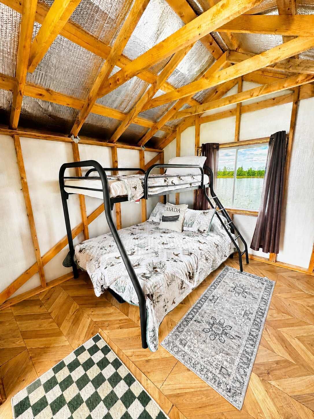 Ein Schlafzimmer mit Etagenbett, einem karierten Teppich und einem gemusterten Teppichboden.