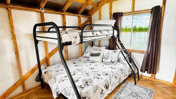 Ein Schlafzimmer mit Etagenbett, einem karierten Teppich und einem gemusterten Teppichboden.