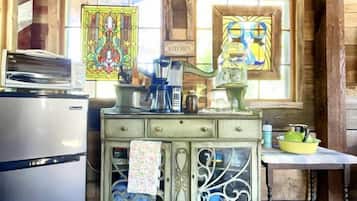 Coffee/tea maker, oven, cookware/dishes/utensils, dining table