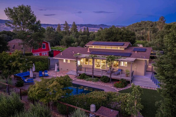 Ein zweistöckiges Haus mit Swimmingpool, Solaranlage und einer Terrasse.
